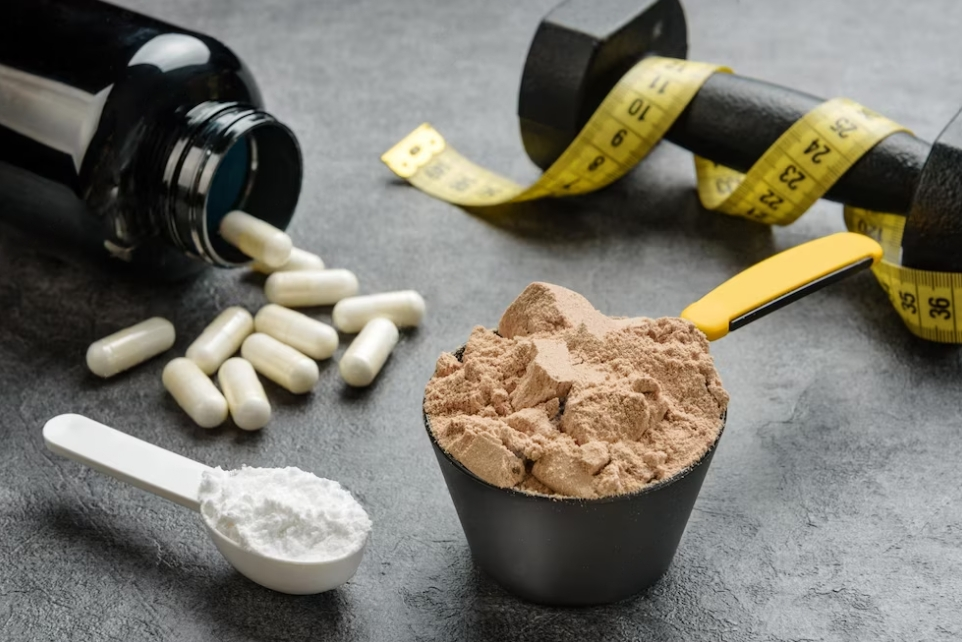 bottles with pills, spoon, and bowl with protein of protein powder