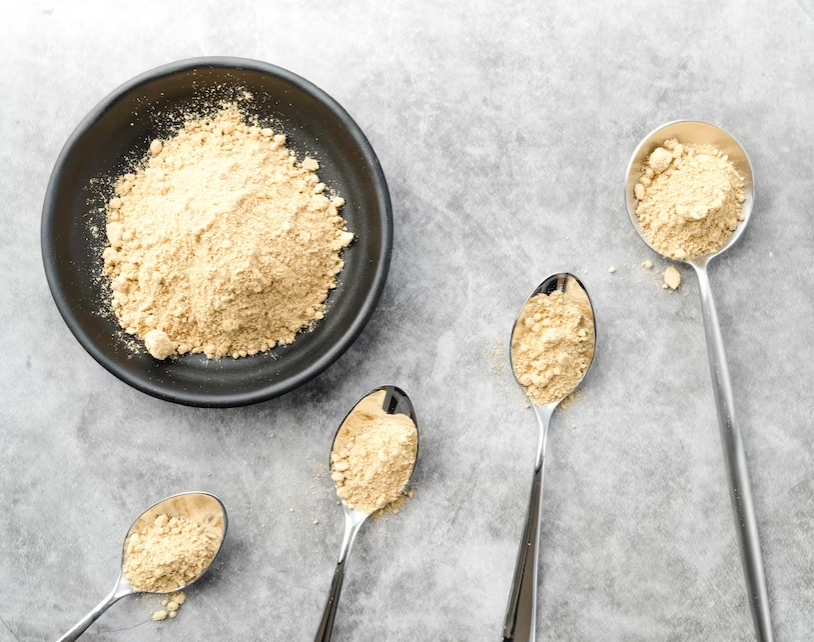 organic food powder in a bowl and spoons on a gray marble table