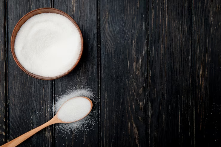 Granulated Sugar in Wooden Bowl and on Spoon