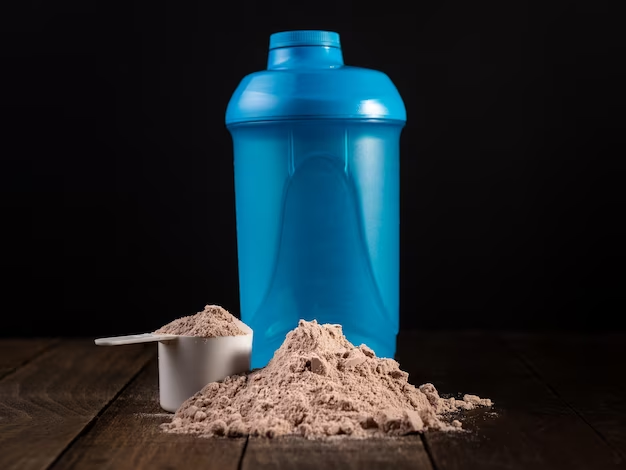 Whey protein spoon and shaker on wooden table