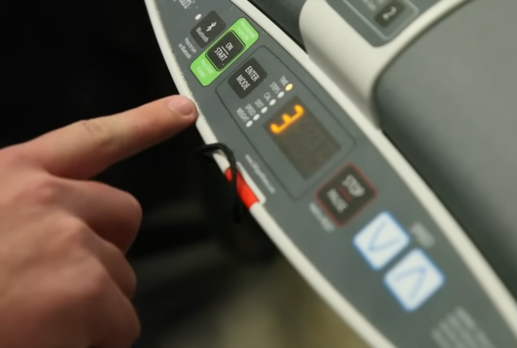 touch screen of treadmill and finger pointing on it