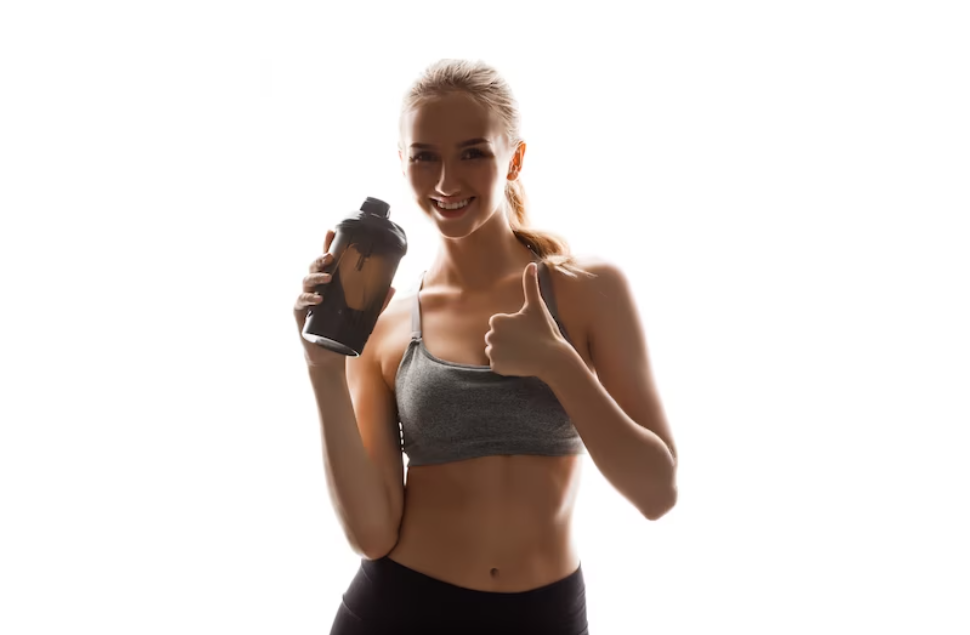 woman in gray top holds a bottle with protein