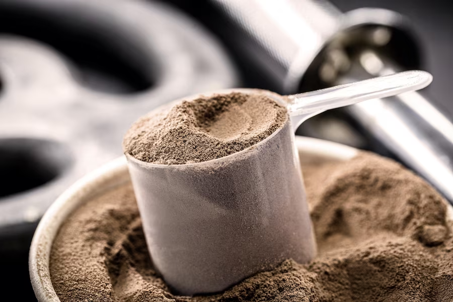 Protein powder scoop on a bowl filled with protein powder