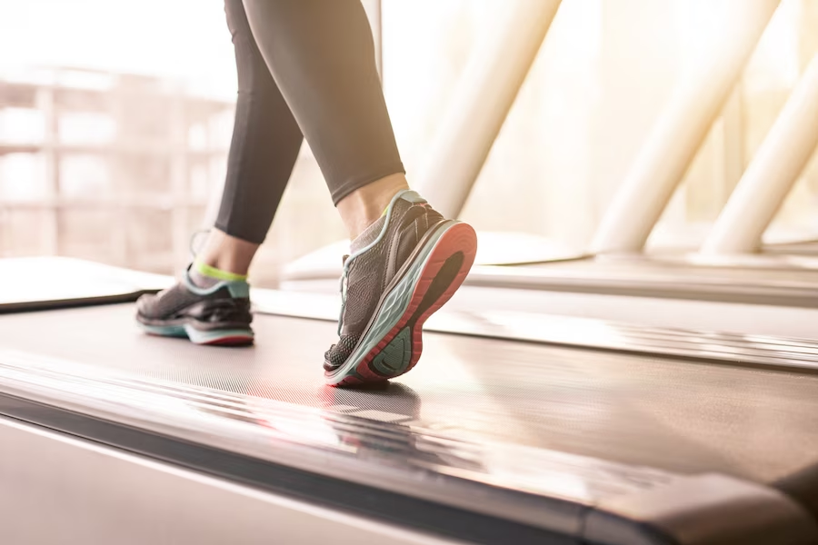 Sneaker-wearing feet on a treadmill in a close-up shot