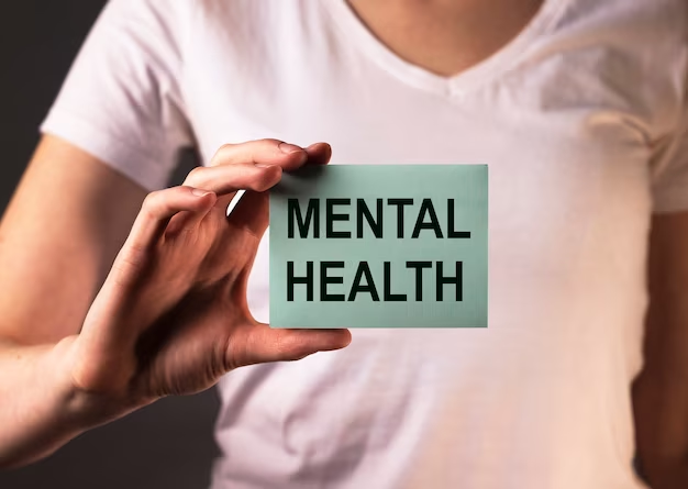 A woman holding a note with the text 'mental health'