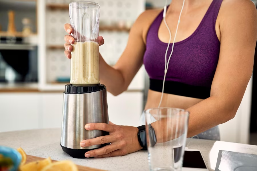 woman preparing a drink using a blender