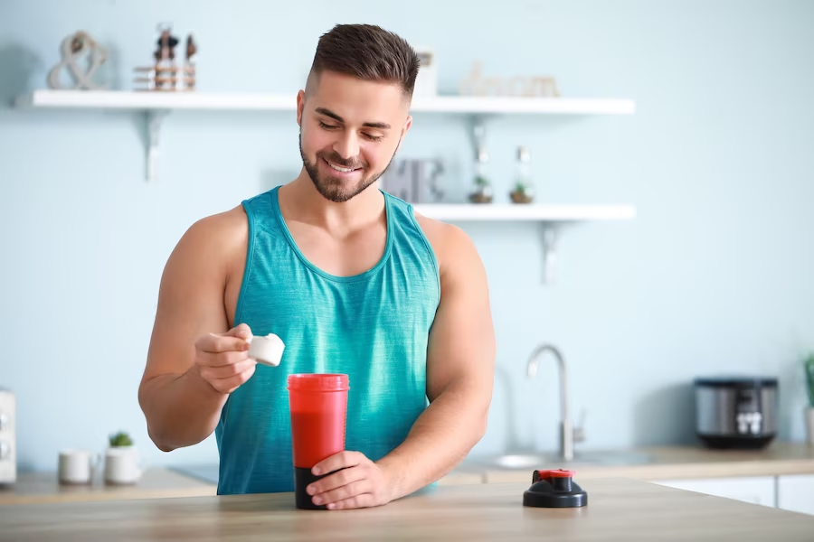 Man pouring scoop of powder into a tumbler