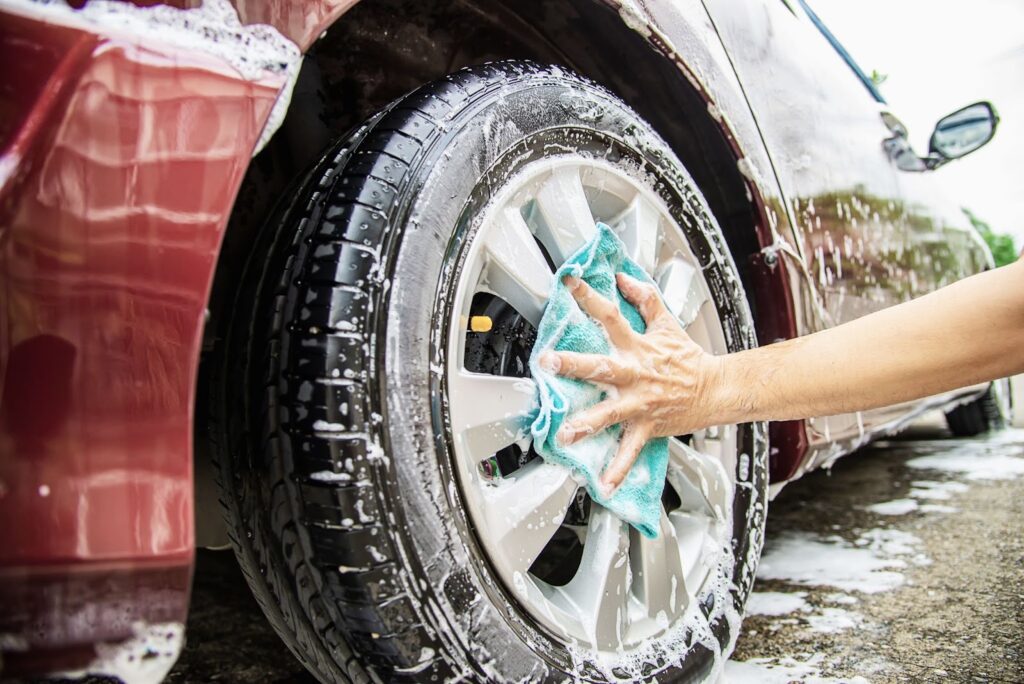 Close up of man washing the rims of a car