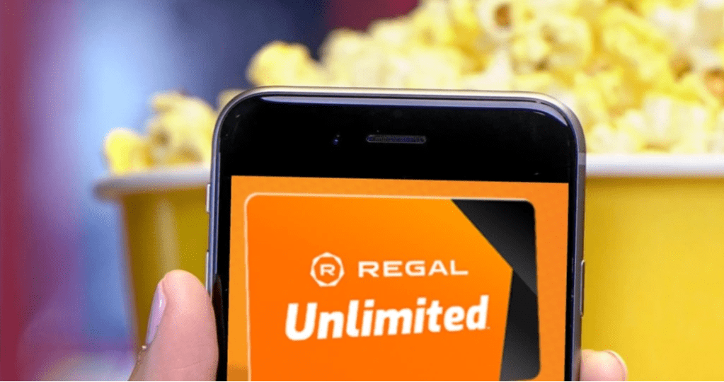 Hand holding smartphone with Regal Unlimited application