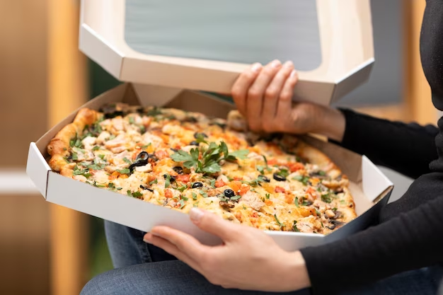 A man opens a pizza box