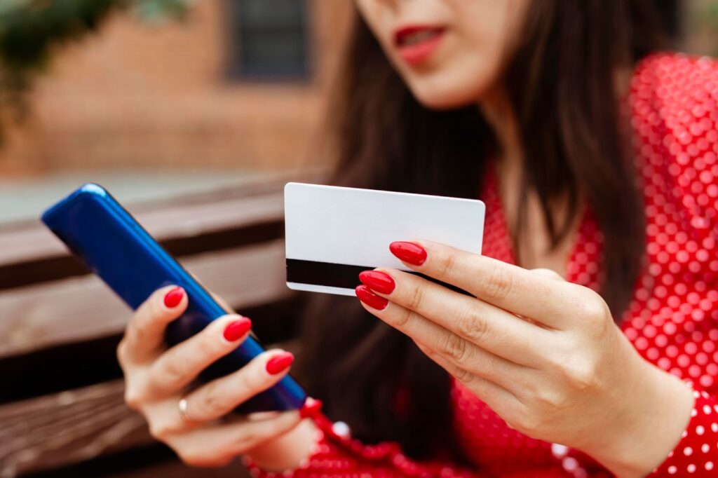 Side view of woman with smartphone and credit card