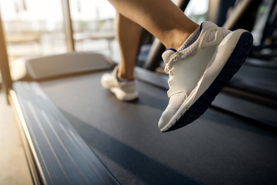 person in white sneakers running on treadmill